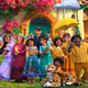 The family members of the Madrigal family in Disney's Encanto, standing in front of their house.